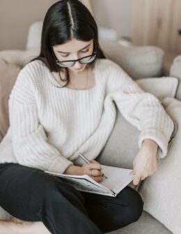 how to journal. daily journaling. journaling daily. journal how to. how to start a journal. how to start journaling. woman sitting on the sofa and writing in a journal
