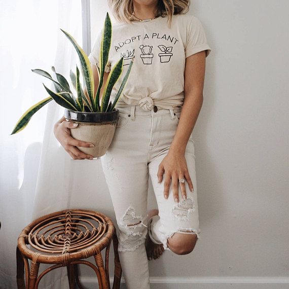 healthy living tips. Tips for healthy living. Best houseplants. keep house plants in the home. Woman wearing adopt a plant t shirt and holding house plant