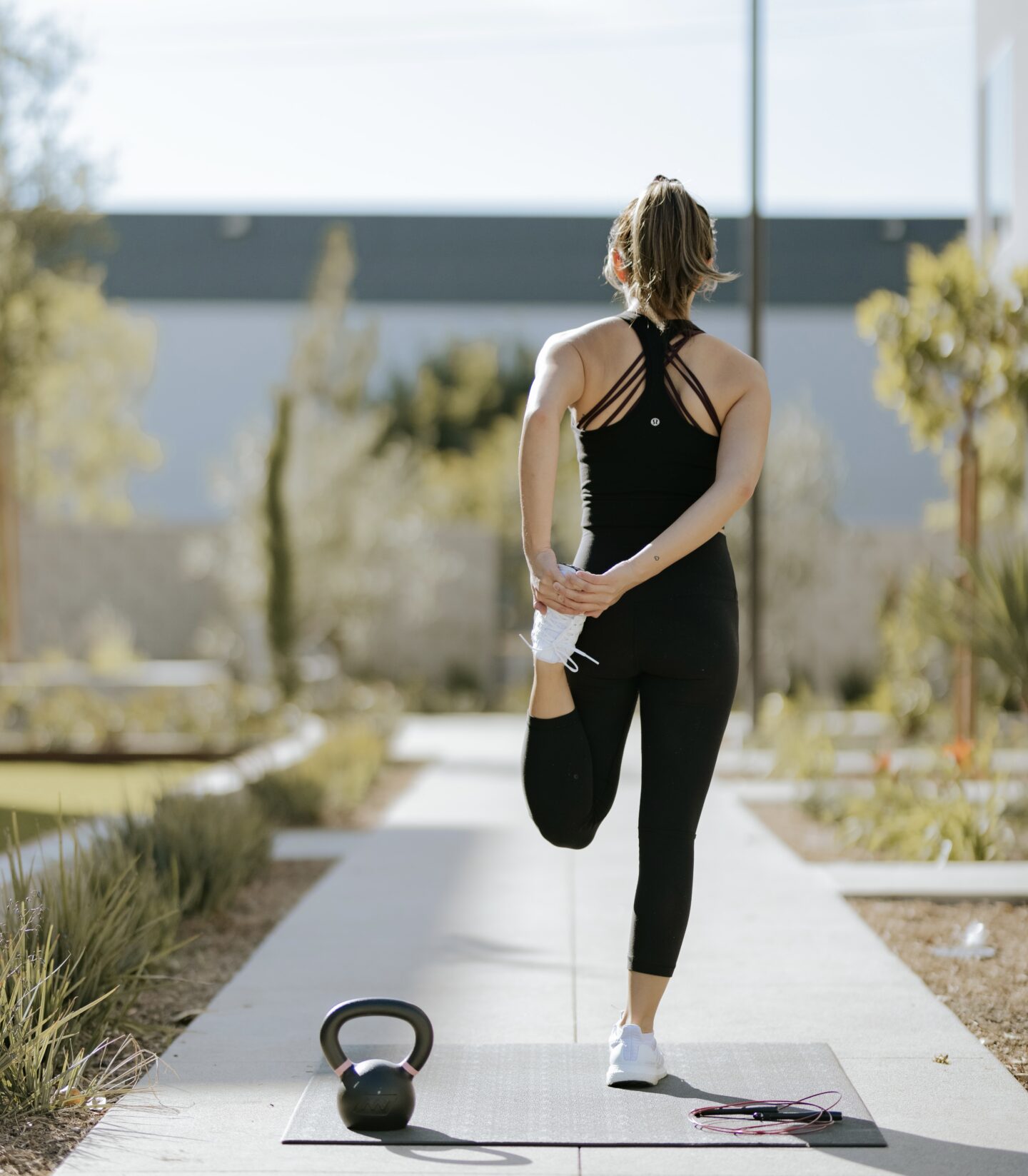 woman doing exercise outside, woman stretching outside, outdoor fitness with dumbells for a healthier lifestyle