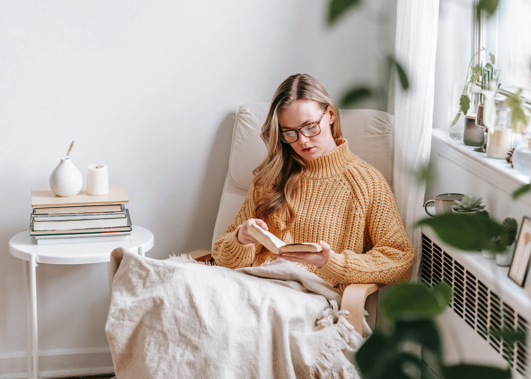 woman sitting cozy on an armchair reading a book. reading nook corner. how to take time for yourself. self care ideas for mind body and soul. self-care ideas for mental health. me time ideas