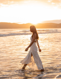 woman walking on the beach during sunset. lifes simple pleasures for happiness and peace.
