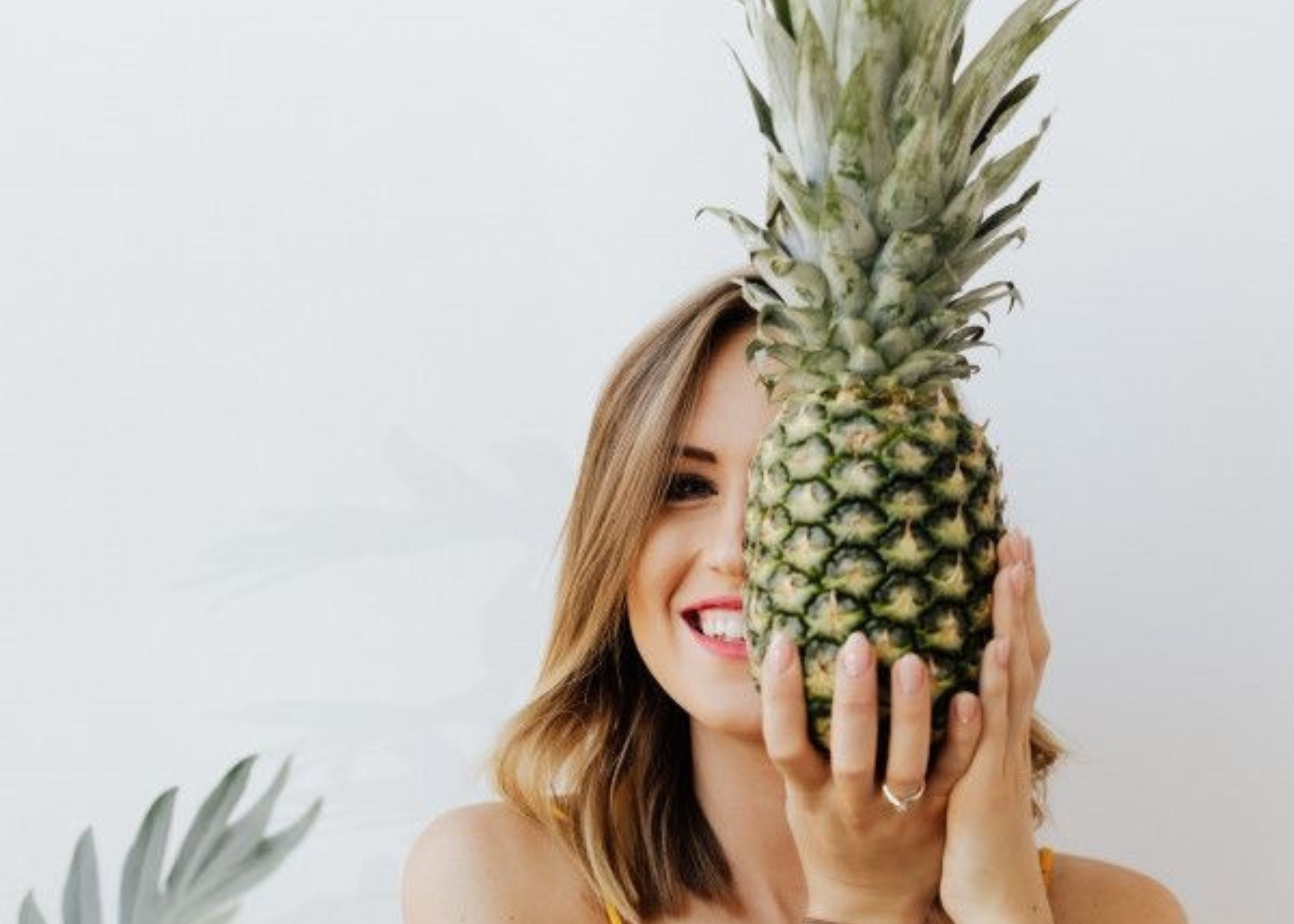 woman holding a pineapple hiding one eye. how to look good every day. how to look put together. how to look your best. how to look better. how to look perfect. look great.