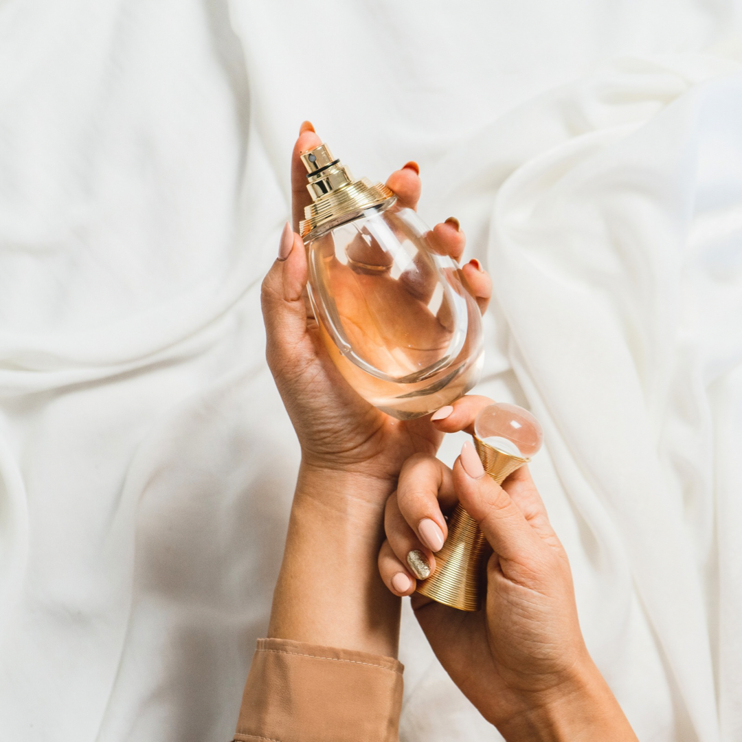 woman holding a perfume in her hand. the best summer fragrances for women. summer perfumes. perfect summer scents. what perfumes are good for summer. how to find the perfect summer fragrance