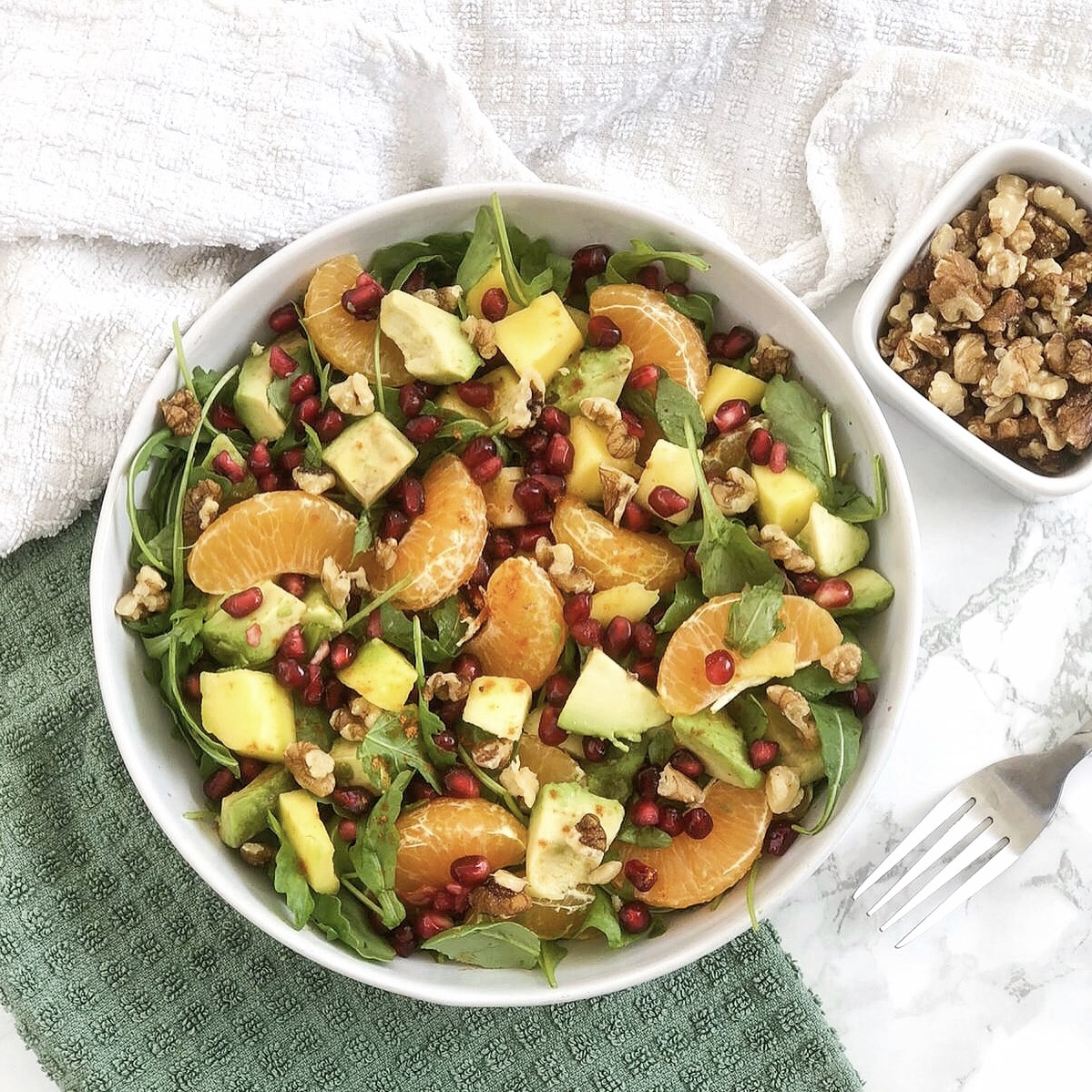 leafy watercress walnut fruit salad with avocados, pomegranates and tangerines